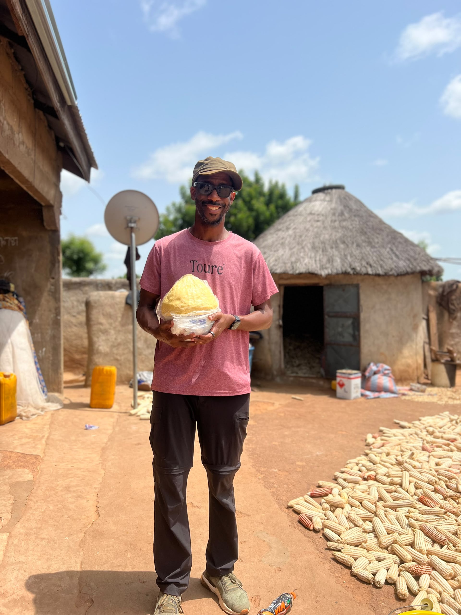 Jerome Fleming with a woman holding a shea butter ball in Ghana
